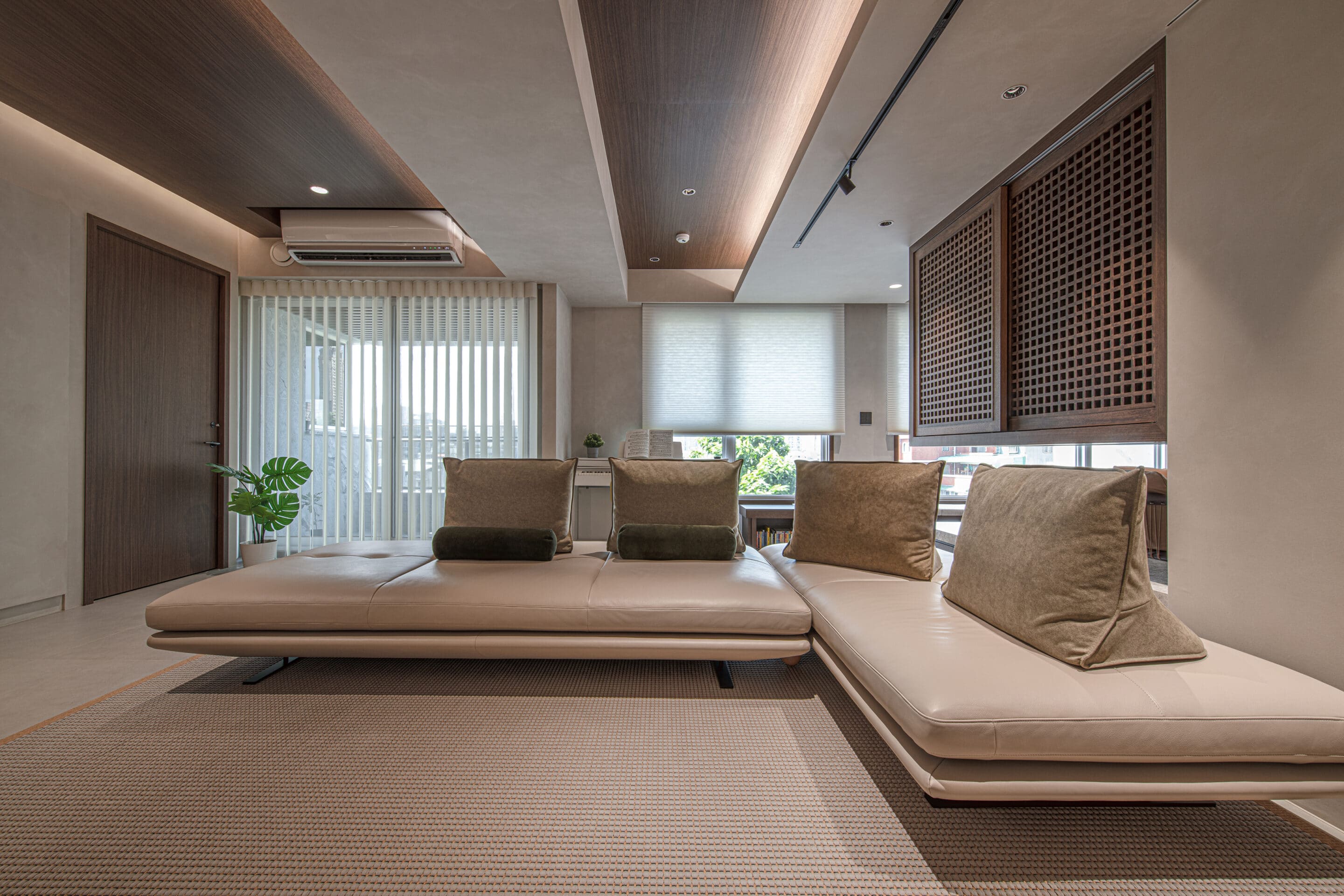 Vertical blinds and cellular shades filtering in light into a sleek living room. 